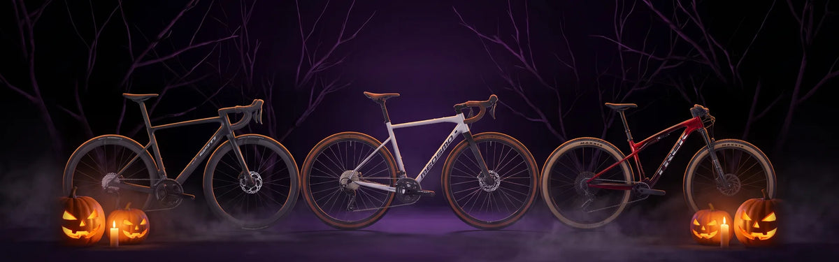 Tre biciclette in uno studio buio con zucche di Halloween